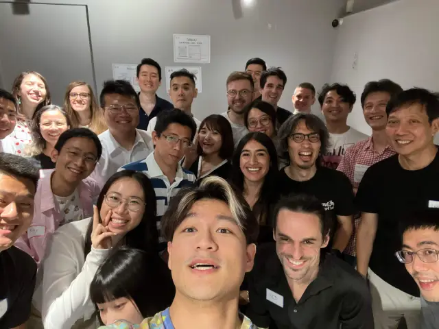 興趣小聚的大合照，參加者擠在鏡頭前，前排有人伸手自拍