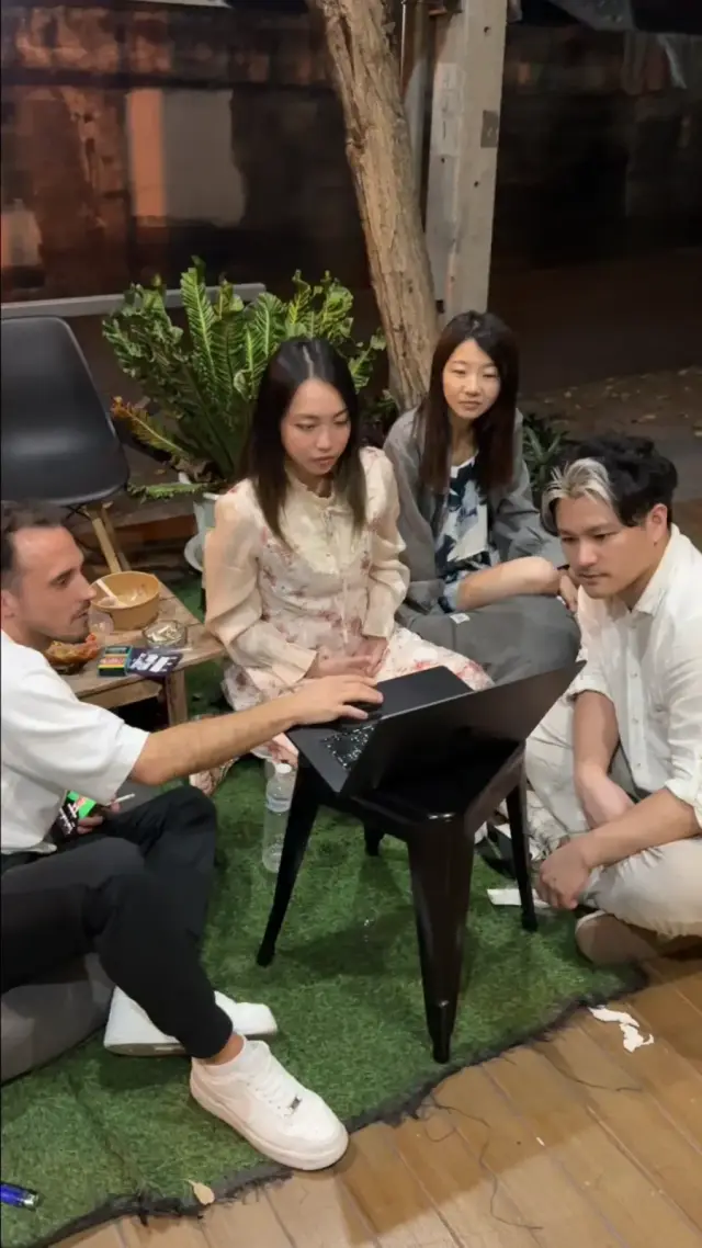 峴港遊牧啟發之旅，四個人坐在草皮上，圍著一台筆電看