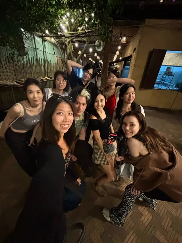 越南旅居體驗，夜裡掛著燈串的巷子裡，一群人擠進鏡頭自拍